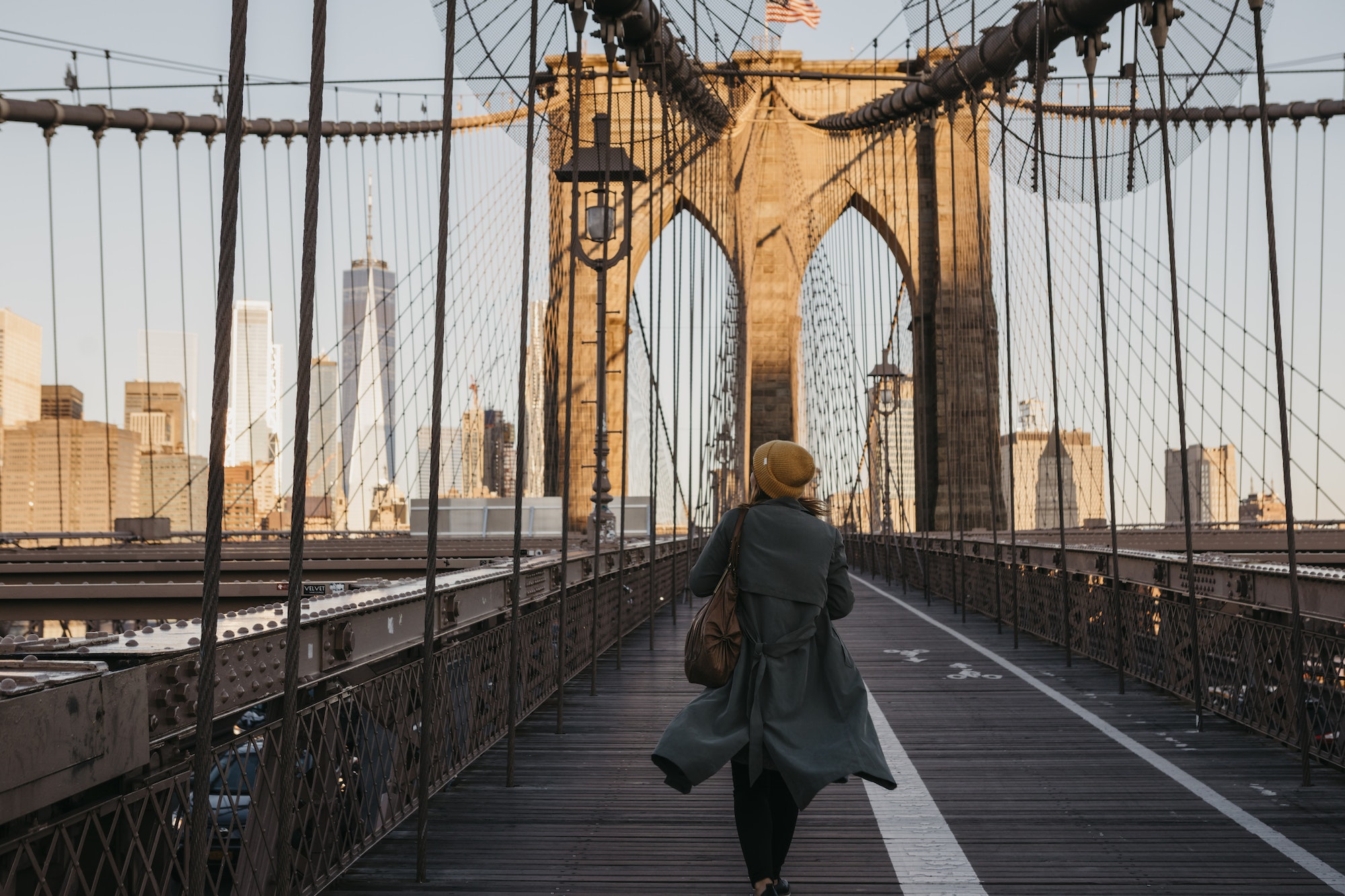 USA, New York, New York City, female tourist on Brooklyn Bridge in the morning light