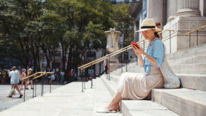 Attractive woman with phone on the steps of a building